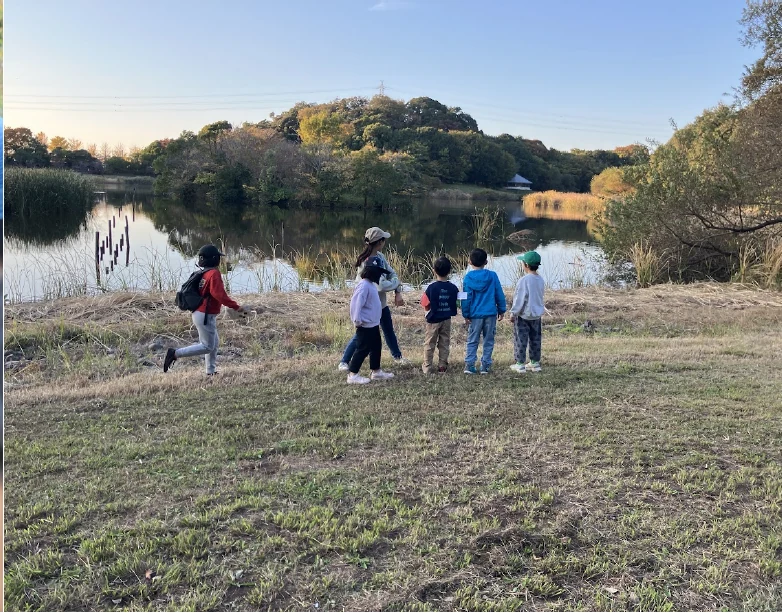 落ち葉の中で遊ぶ子ども